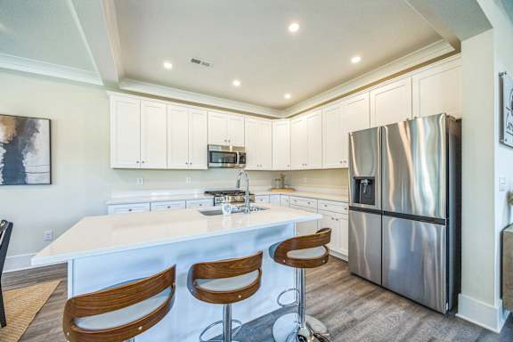 A kitchen with a white island and stainless steel appliances.