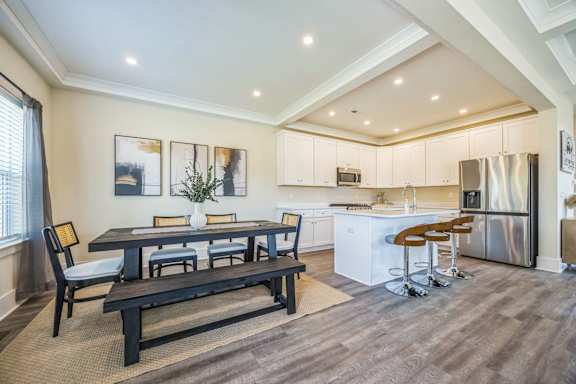 A modern kitchen with a dining table and chairs.