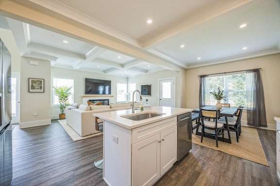 A modern kitchen with a white island and wooden floors.