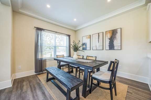 A dining room with a table and chairs.
