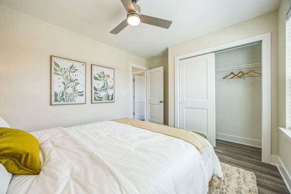A bedroom with a white bed and a yellow pillow.