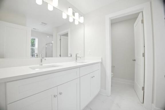 A white bathroom with a sink and mirror.