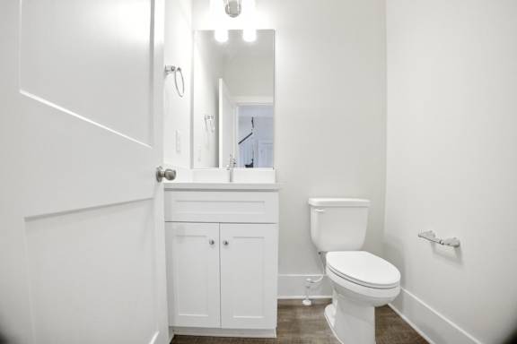 A white bathroom with a toilet, sink, and medicine cabinet.