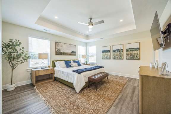 A bedroom with a bed, a bench, and a tree.