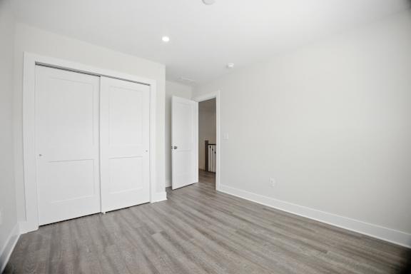 A room with a white door and a grey floor.