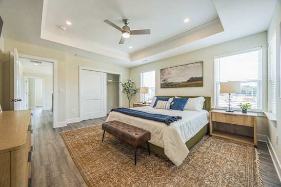 A bedroom with a bed, bench, and a painting on the wall.
