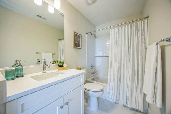 A white bathroom with a white toilet and a white sink.