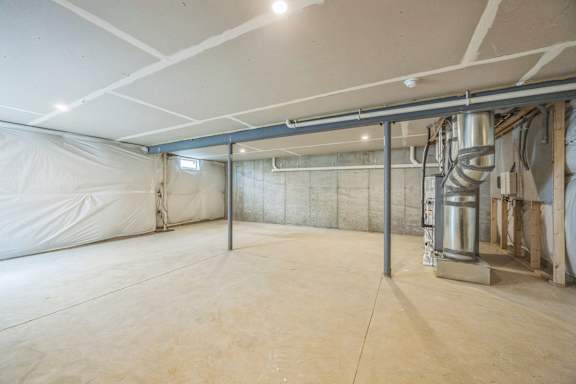 A spacious, empty room with a white ceiling and walls, and a large white curtain on the left side.