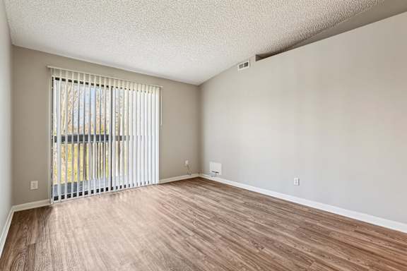 A bedroom with a bed, chair, and a painting on the wall.