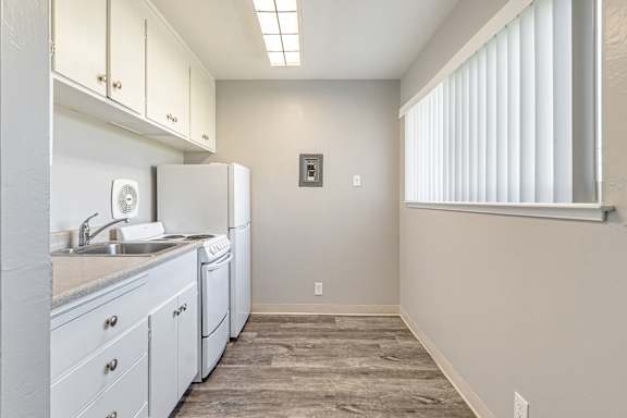 A kitchen with white appliances and cabinets.