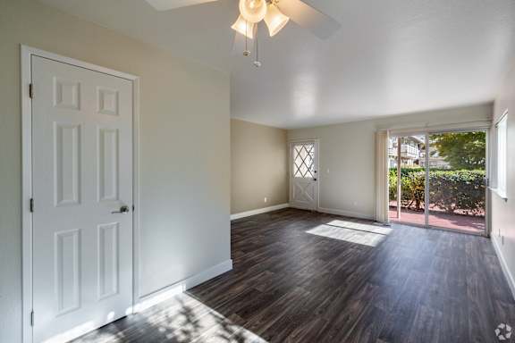 an empty living room with a door to a patio