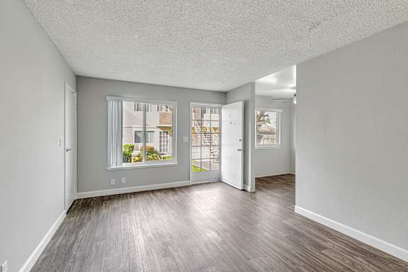 A room with a carpeted floor and a window with blinds.