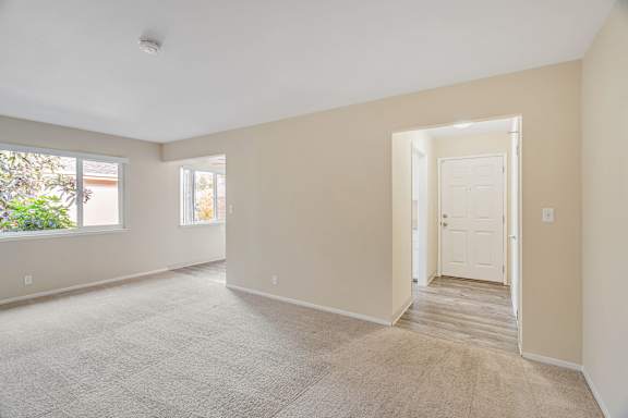 A room with wooden floors and a window with blinds.