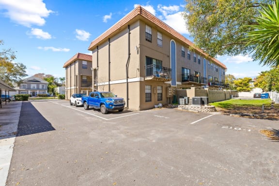 a building with a parking lot with cars in front of it