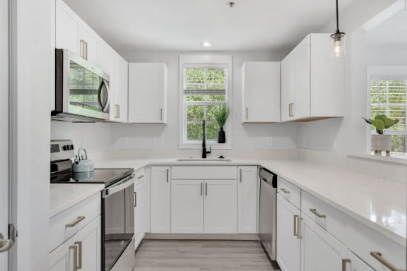 a white kitchen with white cabinets and a sink