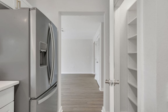 a renovated kitchen with stainless steel appliances and white shelves