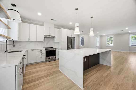 A modern kitchen with white cabinets and a large island.