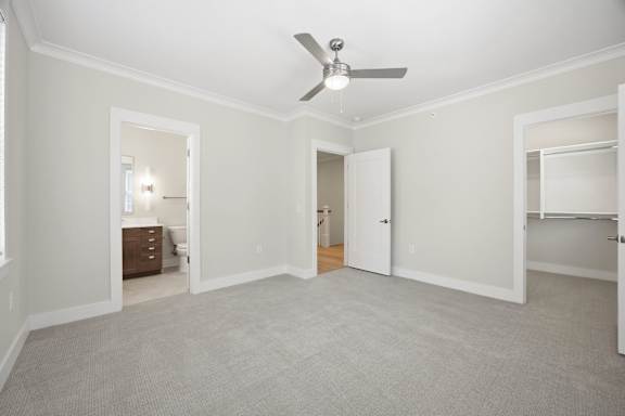 A room with a ceiling fan and carpeted floor.