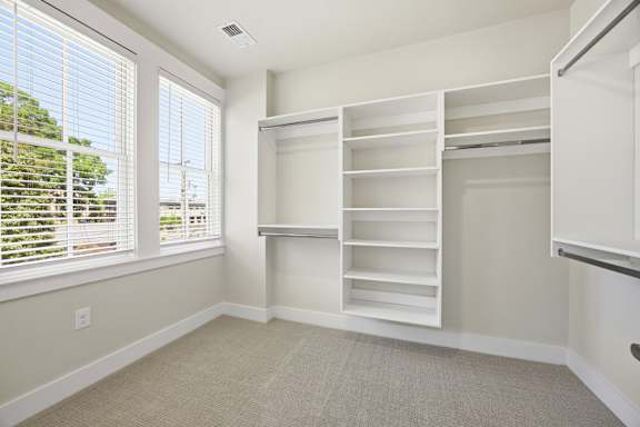 A room with a large window and a built-in shelving unit.
