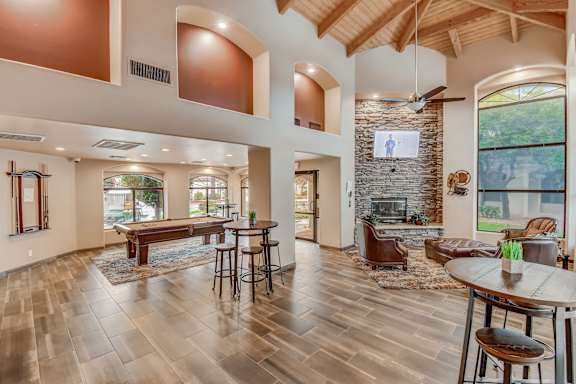 A spacious living room with a fireplace and a dining table set up.