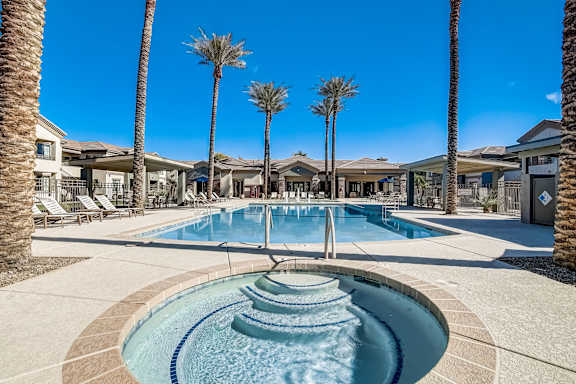 A pool surrounded by palm trees and a fountain in the middle at Adiamo Palm Valley, Goodyear, Arizona