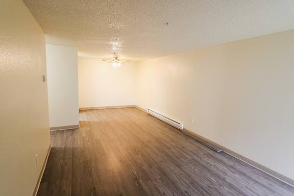 A room with wooden flooring and a ceiling fan.