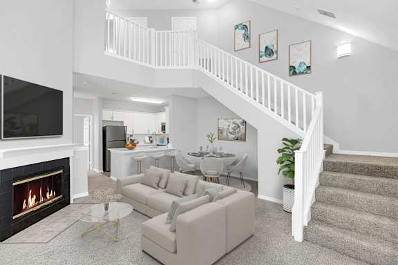 a living room with a staircase in the background and a couch in the foreground at Northlake Park Apartments, Orlando