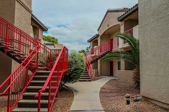 A red staircase leads to a building entrance.