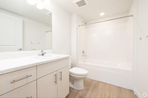 A white bathroom with a toilet, sink, and bathtub.