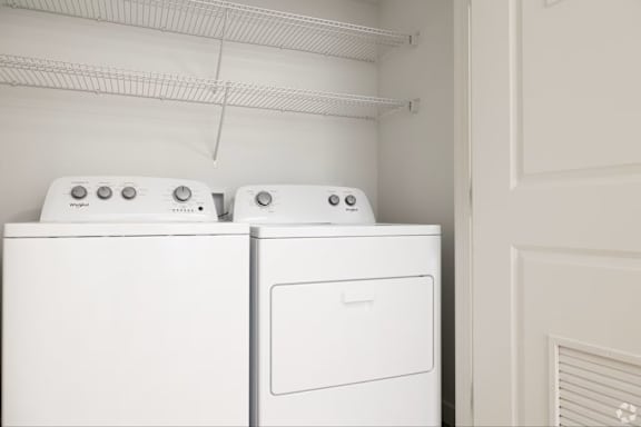 Two white ovens are stacked on top of each other in a kitchen.
