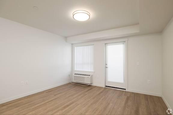 A room with a white door and a window with blinds.