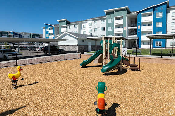 A playground with a slide, a rubber duck, and a toy cannon.