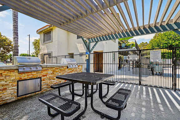 A patio with a table and chairs under a roof.