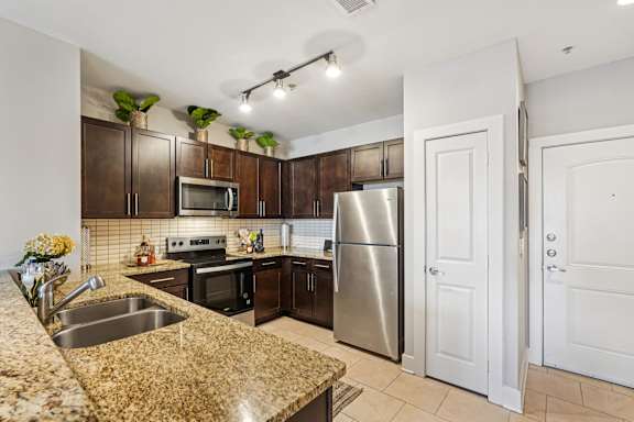 A kitchen with granite countertops and stainless steel appliances.