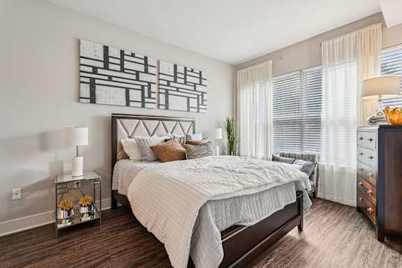 A bedroom with a large bed and a painting on the wall.