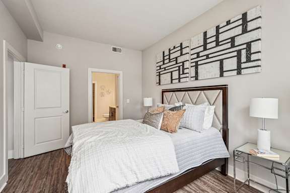 A bedroom with a large bed and a painting on the wall.