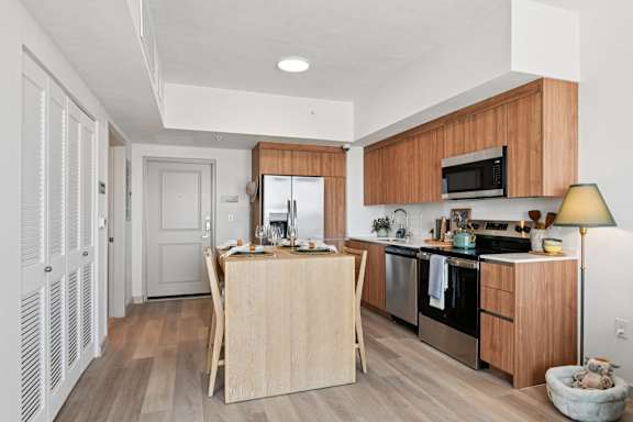 A kitchen with wooden cabinets and a white interior.