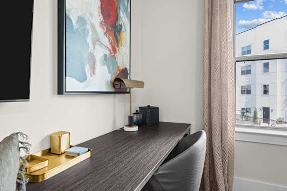a home office with a desk and a large painting on the wall