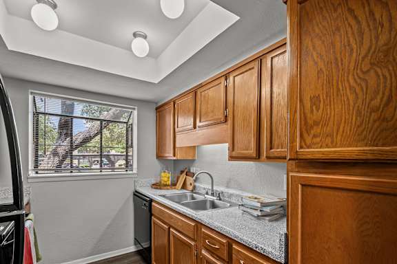 a kitchen with wooden cabinets and a sink and a window