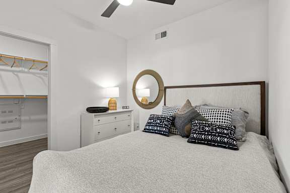 A bedroom with a bed, dresser, and mirror.
