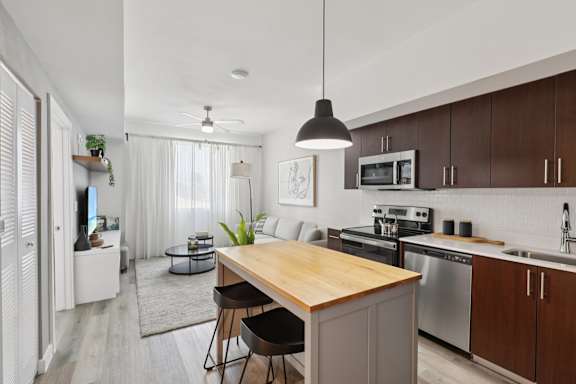 A modern kitchen with a wooden island and stainless steel appliances.
