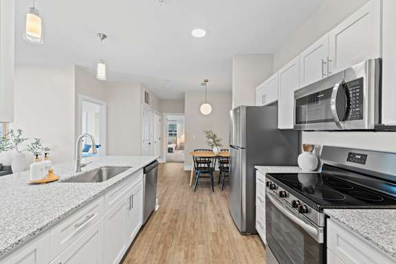 A modern kitchen with stainless steel appliances and white cabinets.