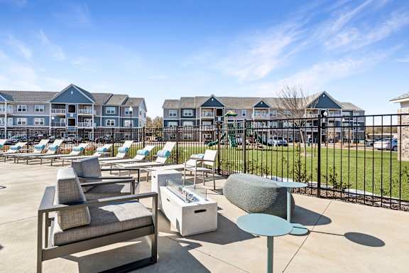 A sunny day at a resort with lounge chairs and tables.