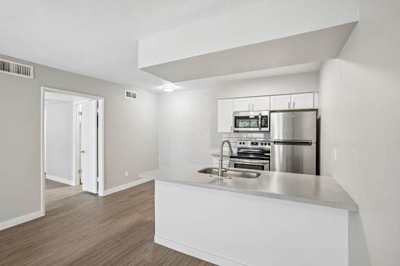 A modern kitchen with stainless steel appliances and white cabinetry.