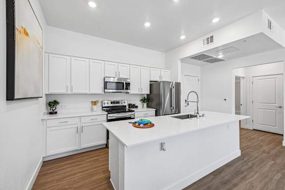 A white kitchen with a large island in the middle.