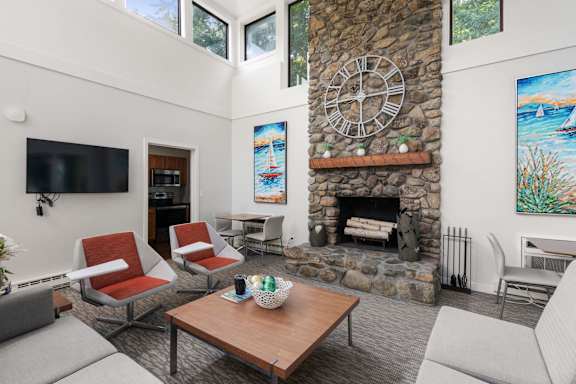A modern living room with a television, a couch, and a potted plant.