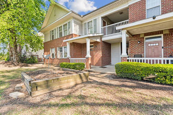 A apartment with a red brick exterior and brown doors..