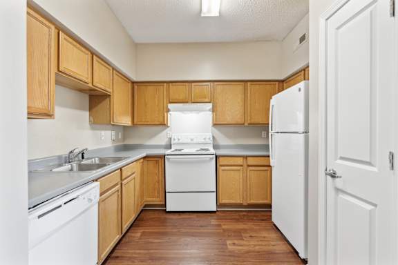 A kitchen with wooden cabinets and white appliances.