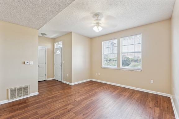 A living room with a window and a wooden floor.