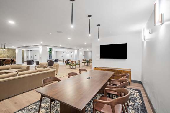A conference room with a long table surrounded by chairs.